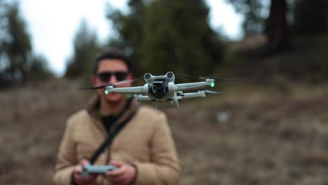 man operating a dji mini 3 pro drone outdoors