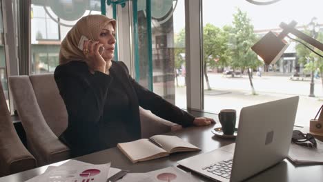 middle eastern business lady making phone call in cafe