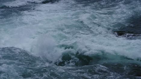 close-up view of intense whitewater rapids crashing and swirling over rocks, capturing the raw power and turbulence of a wild river current