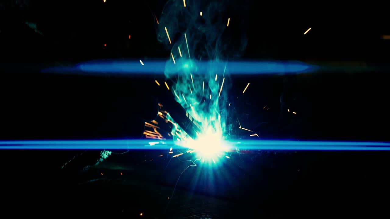 soldador de metal trabaja con un soldador de acero en una fábrica con equipo de protección