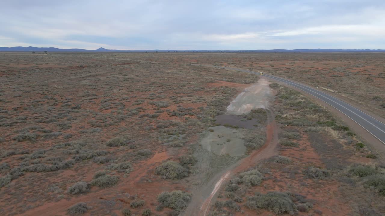 aéreo rápido siguiendo el coche cruzando la carretera rural del interior de australia, paisaje árido