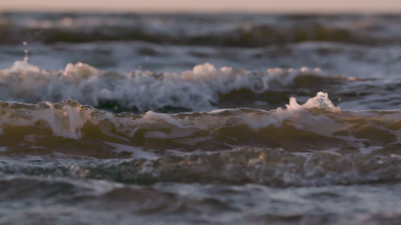 Sea waves rushing at the beach during sunset