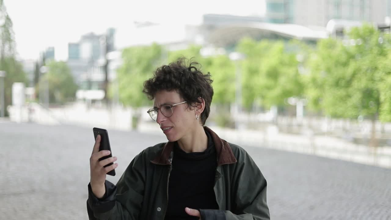 mujer emocional teniendo video chat al aire libre