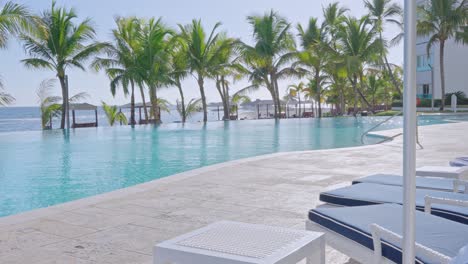 Alluring-pool-at-Caribbean-resort-with-palm-trees,-right-on-the-beach