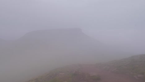 clouds and fog slowly rolling over pen y fan in brecon beacon hills, wales, uk 4k