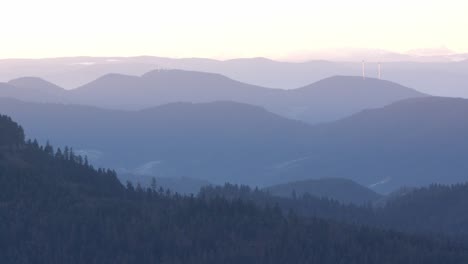 Toma-De-Lapso-De-Tiempo-Del-Amanecer-En-Una-Capa-Montañosa-Con-Molinos-De-Viento-En-La-Distancia