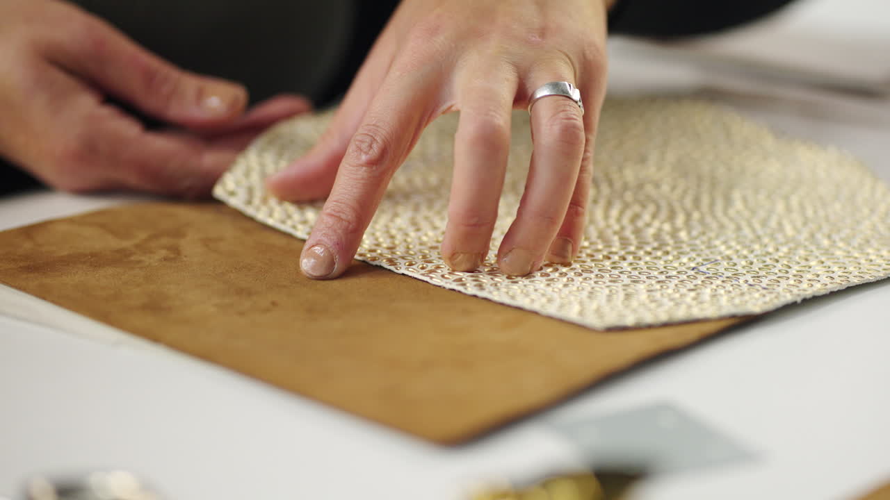 Close-up of hand working with leather and fabric
