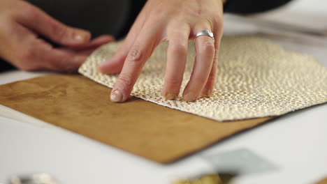 close-up of hand working with leather and fabric