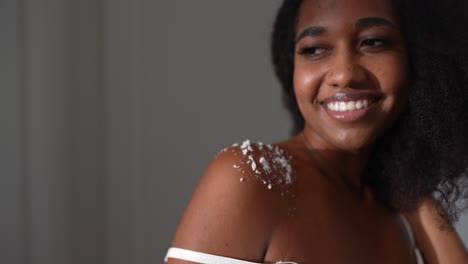 mujer sonriente con polvo en el hombro