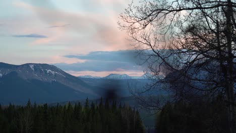 slow-motion shot of a sunset in the canadia rockies with the snowed mountain on the horizon