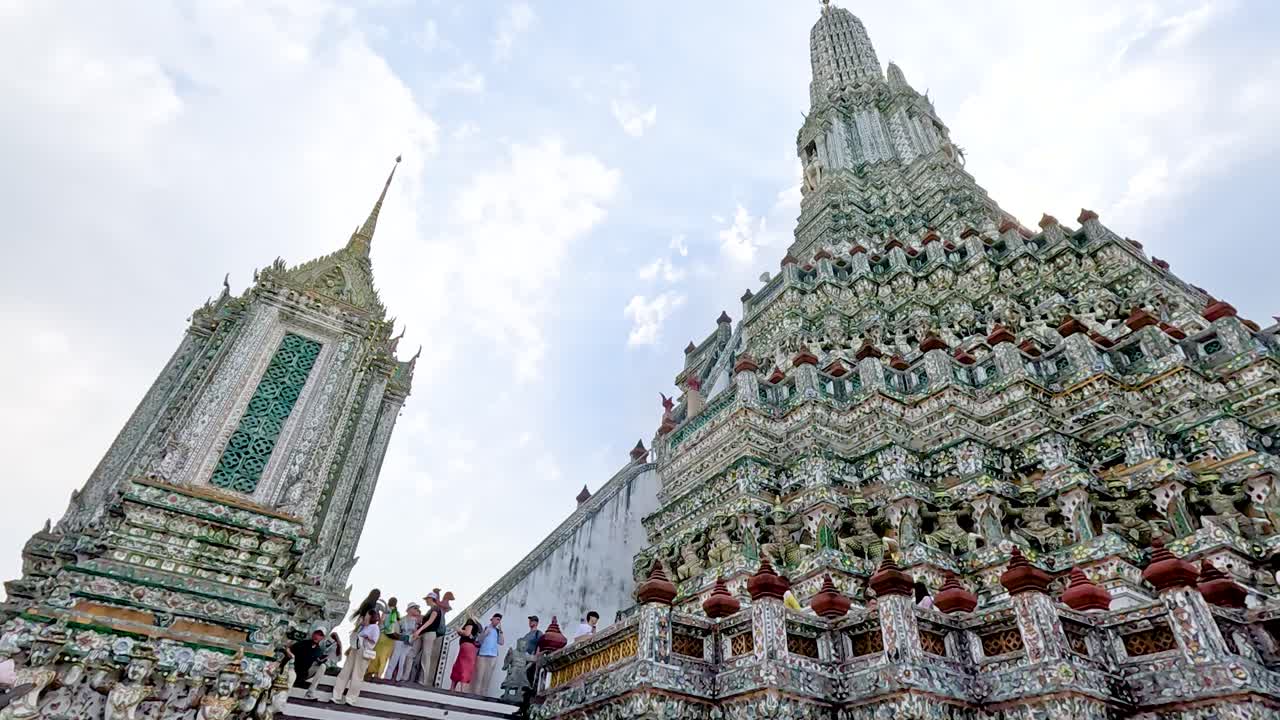 visitantes explorando el ornamentado templo de wat arun en bangkok, tailandia
