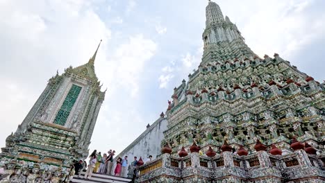 visitors exploring ornate wat arun temple in bangkok, thailand