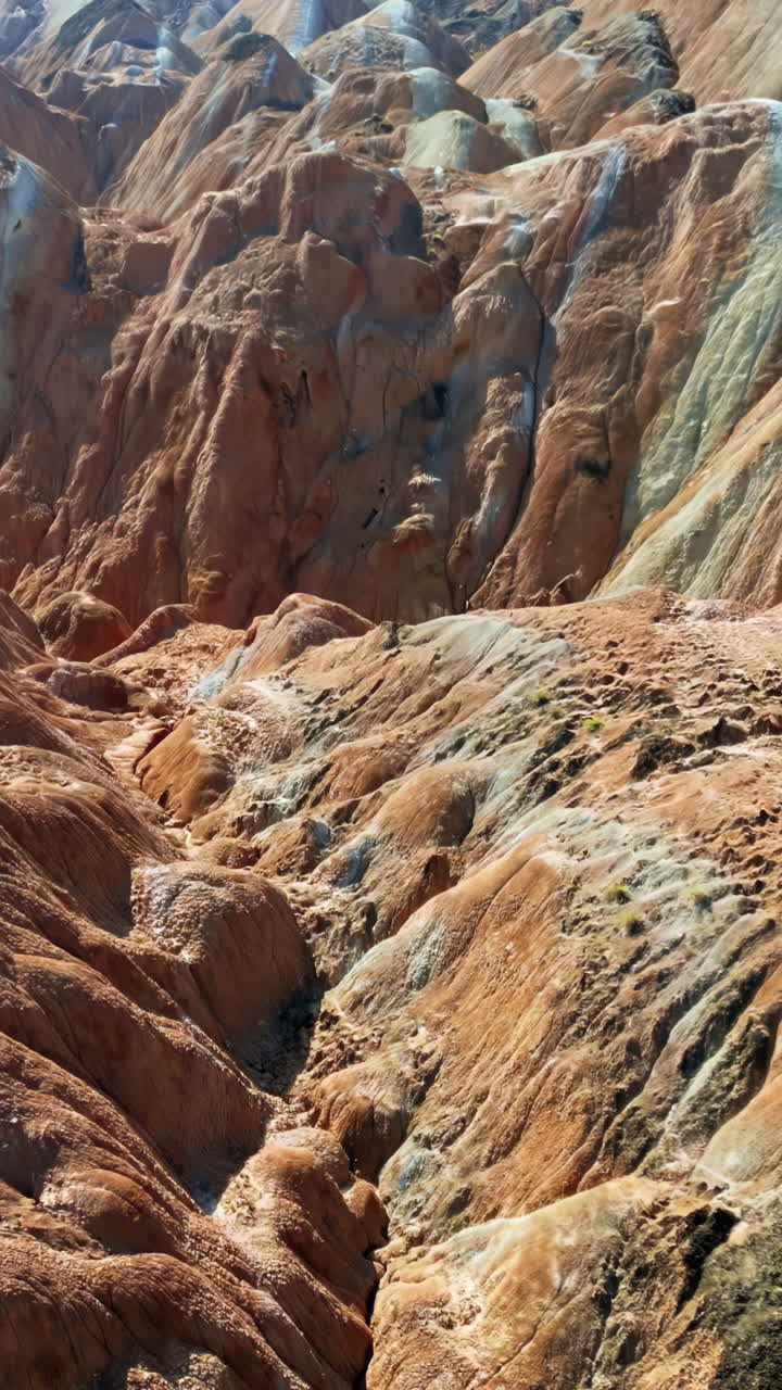 Ilmakuva dronella eroosioituneista hiekkakiviharjanteista Zhangye Danxia -geopuistossa, Gansussa, Kiinassa. Pystysuunta