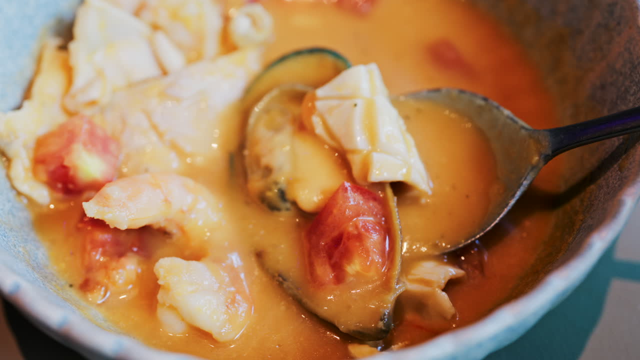 Close up of a creamy seafood stew with mussels, squid, and shrimp