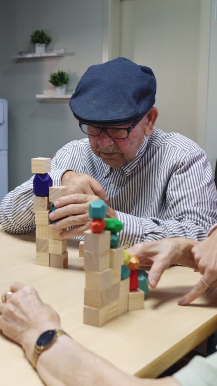 Elderly person playing with wooden blocks in assisted living
