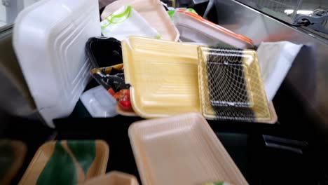 plastic waste is being recycled at the recycling plant. plastic boxes, foam, and paper packaging are moving along the conveyor belt of the sorting line.