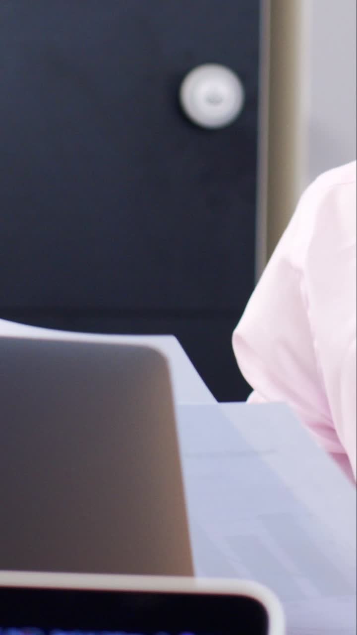 Young Man In Face Mask Looking at Papers In Modern Office