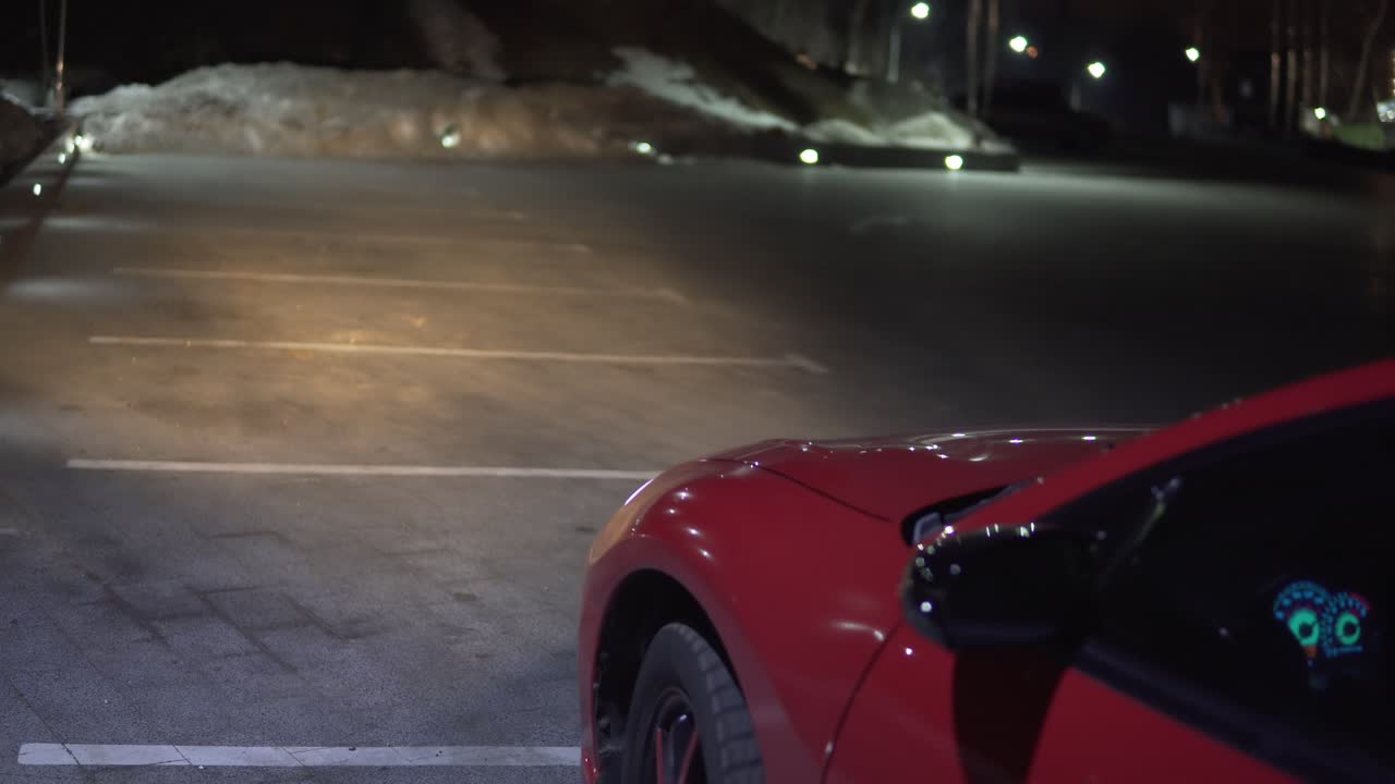 빨간 자동차가 주차장에서 뒤로 달리고 있습니다.