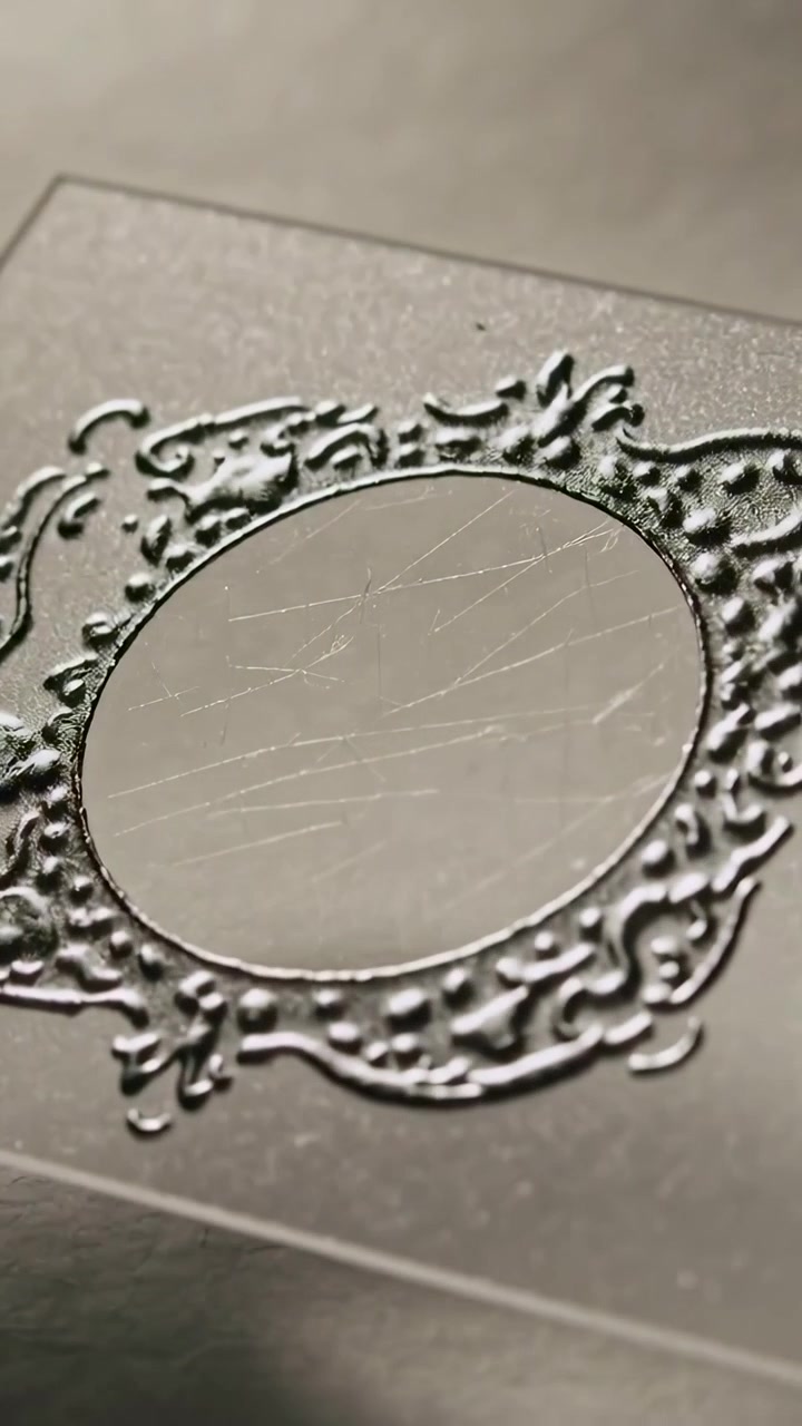 Video vertical: Cámara moviéndose revelando un marco plateado ornamentado y un espejo rayado sobre una tarjeta en una mesa.