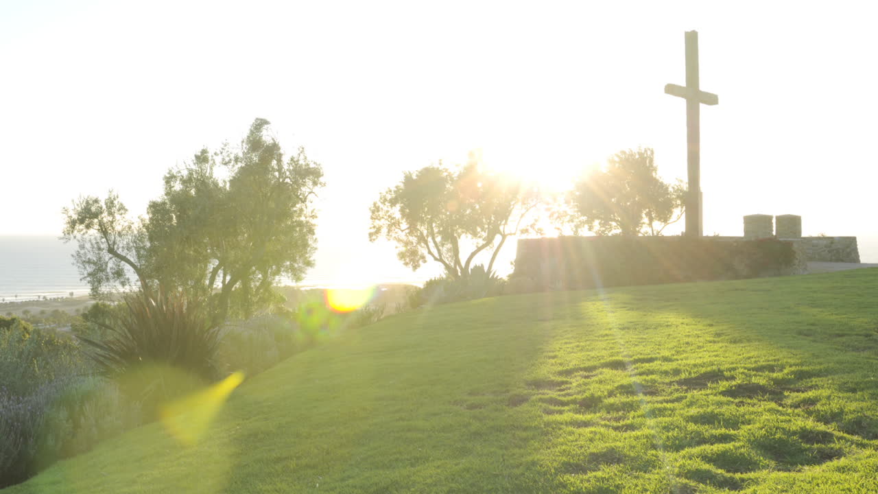 벤추라 캘리포니아에 있는 그랜트 공원에서 십자가 뒤에서 석양을 즐기는 사람들의 시간 경과