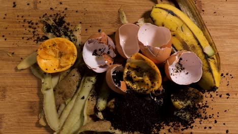 compost material laid out on a cutting board, eggshells, coffee grounds, banana peel