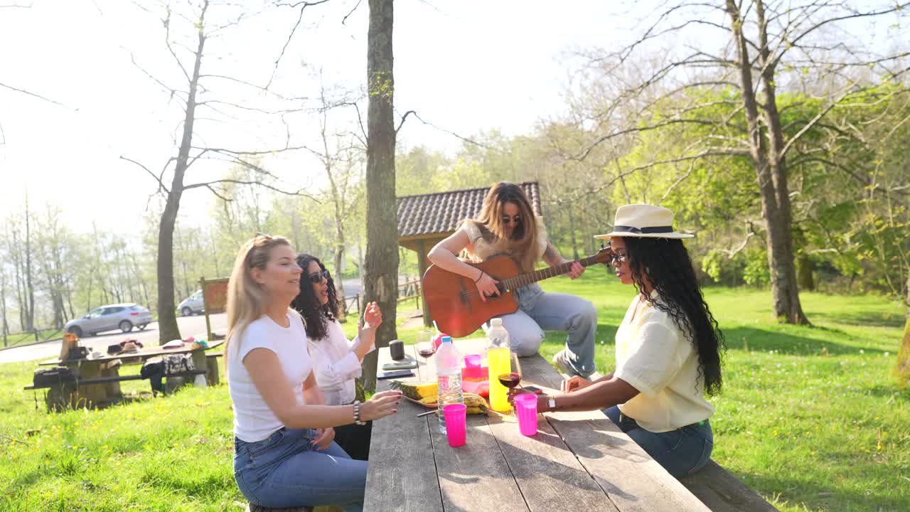 Group of friends having a picnic with music