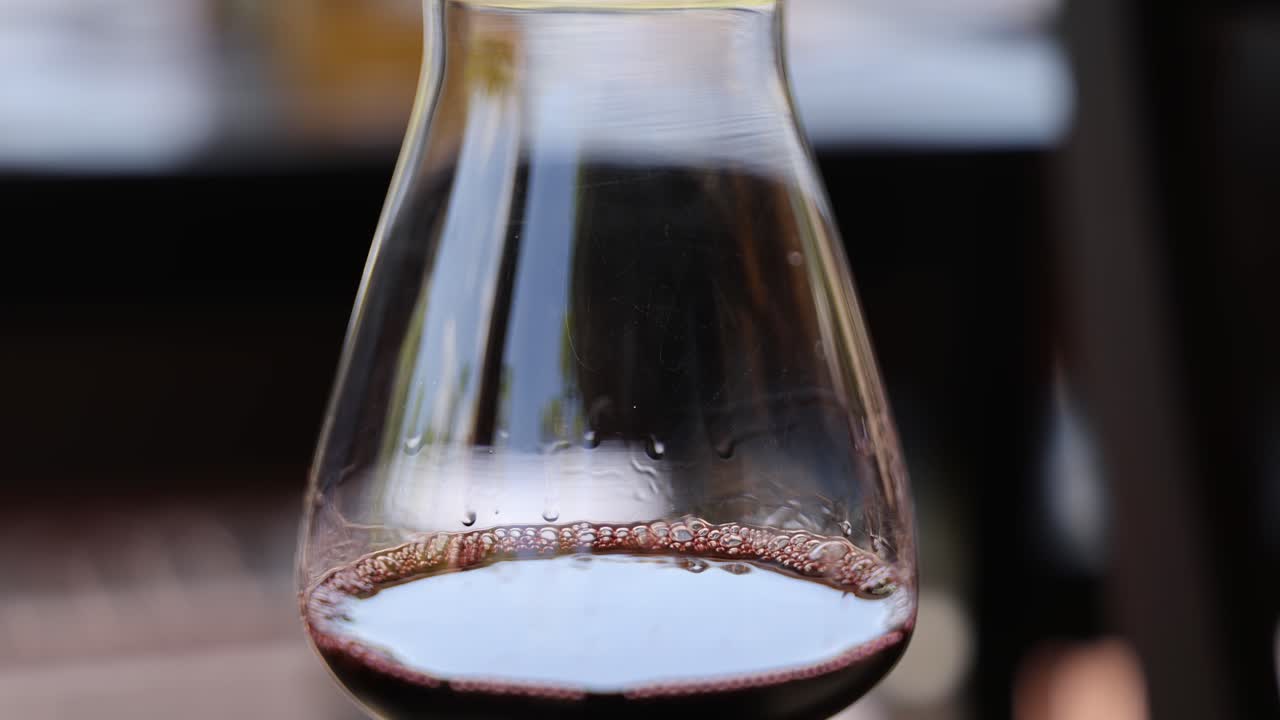 el vino se vierte en un frasco de vidrio