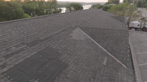 aerial view of a damaged commercial roof showcasing repair patches and wear.