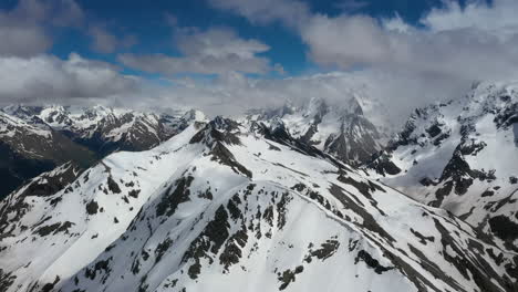 Flug-Durch-Bergwolken-über-Wunderschöne-Schneebedeckte-Gipfel-Von-Bergen-Und-Gletschern.