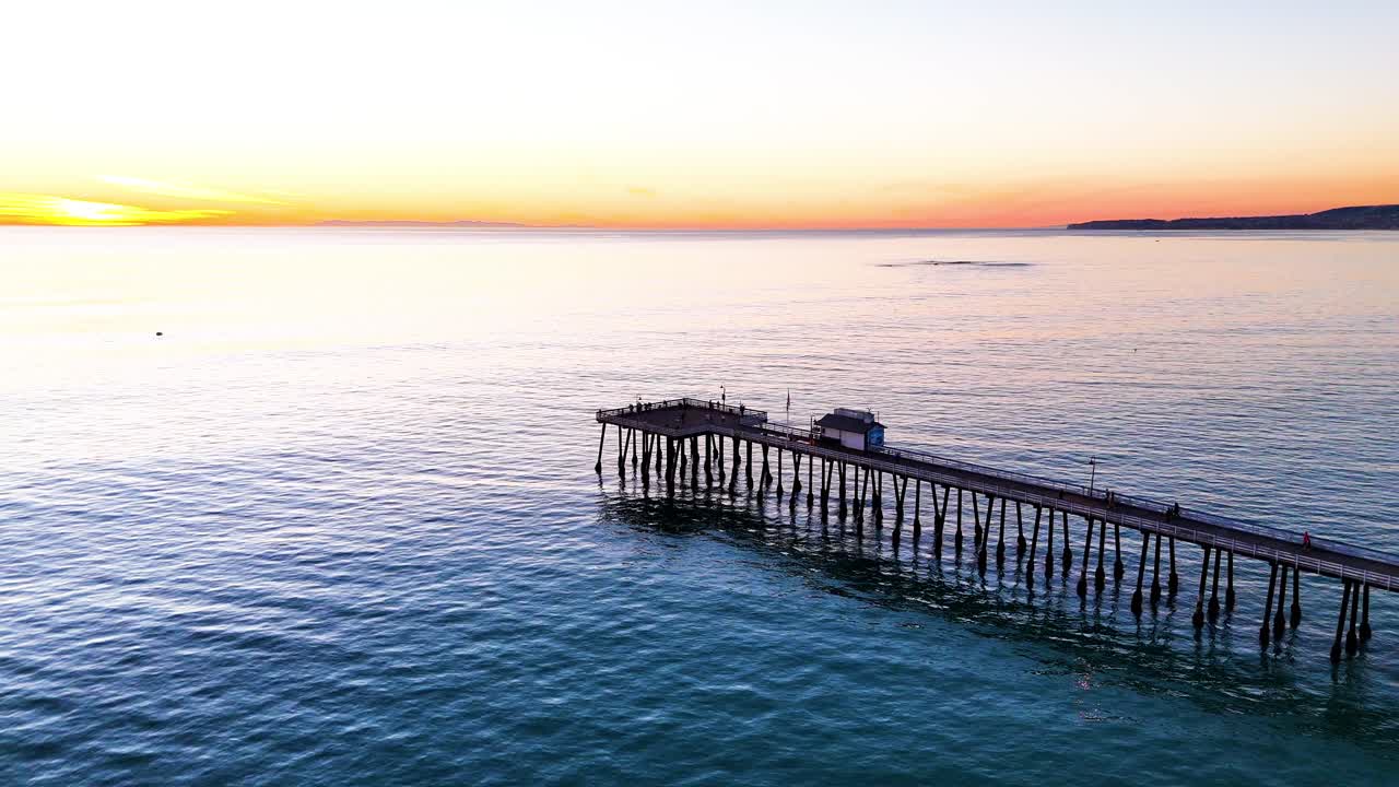 Aerial View of southern california pier with a beautful orange sunset