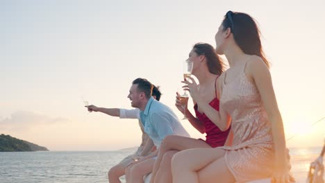 friends celebrating sunset on yacht