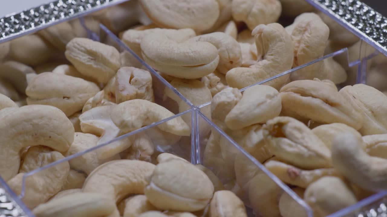 whole cashew nuts in a fancy plastic box, 4k, close up, Parallax shot