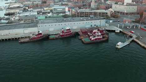 aerial orbit drone footage of tugboats docked at wharf in portland, maine, usa