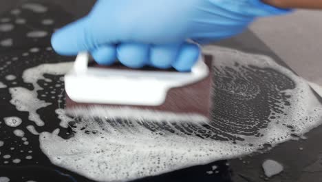 cleaning a glass cooktop with soap and sponge