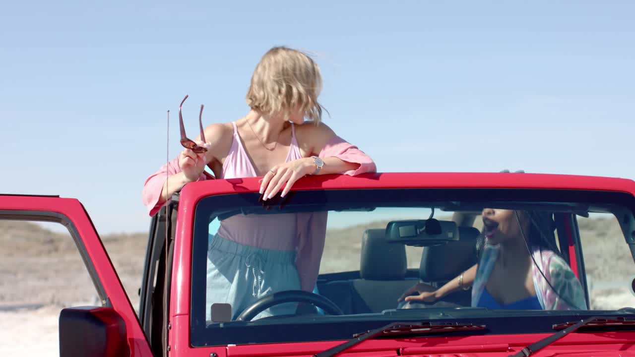 Fröhliches Paar rennt am Strand und Freunde im Cabrio-Jeep