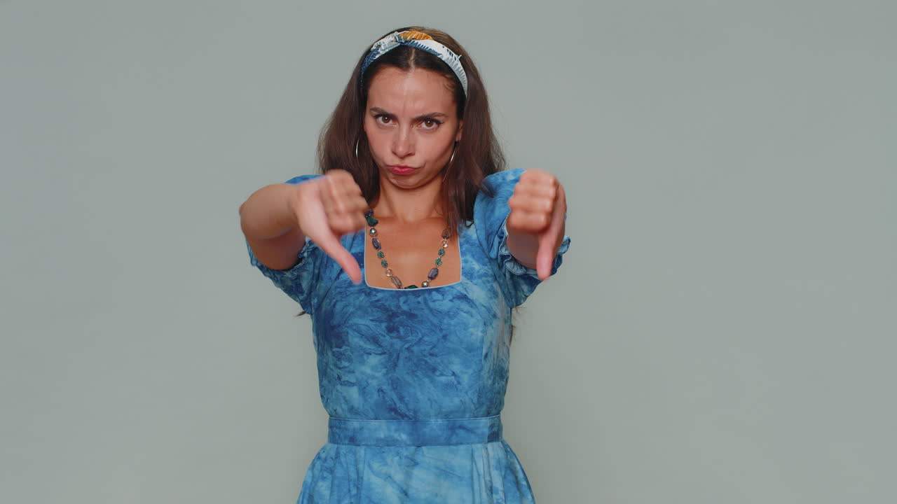 mujer molesta mostrando los pulgares hacia abajo gesto de señal, expresando descontento desaprobación insatisfacción disgusto