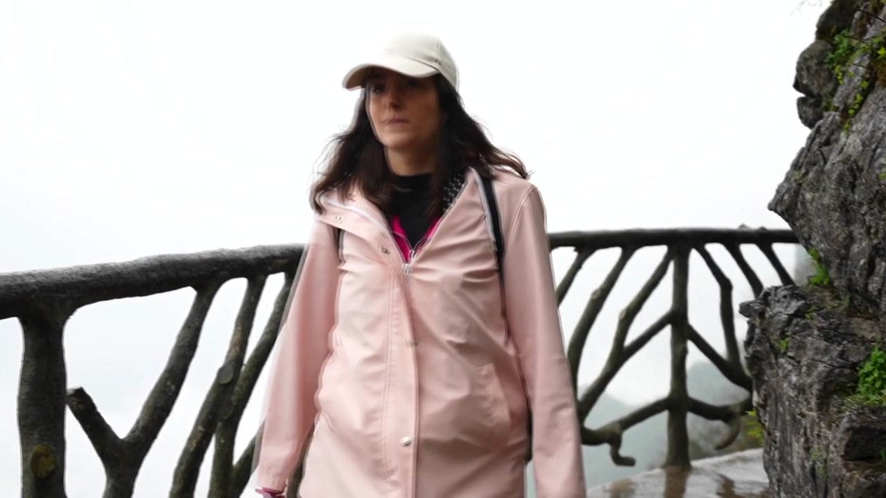 中国の張家界国家森林公園で、崖沿いの道を歩く若い女性旅行者