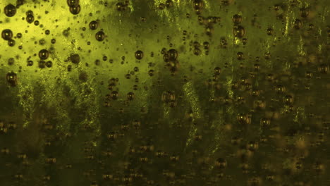 macro slowmo small bubbles rising in green viscous