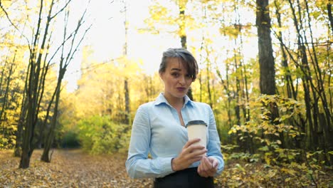 woman spending time in park. young woman spending time with cup of coffee in autumn park
