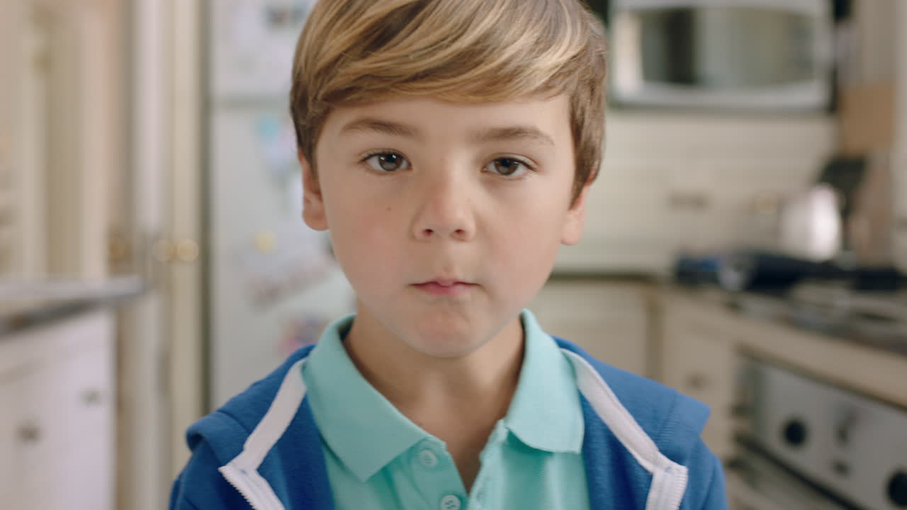 retrato de un niño feliz mirando a la cámara con una expresión curiosa niño lindo en casa en la cocina