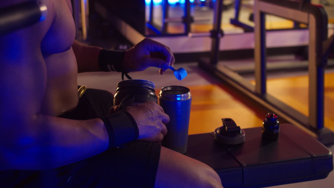 체육관에서 단백질 쉐이크를 준비하는 근육질의 남자