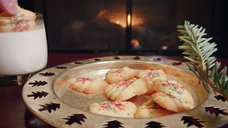 woman grabs a christmas cookie and dips it in milk in 4k
