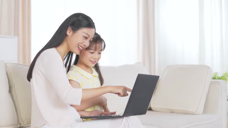 Happy-mother-enjoy-with-her-little-girl-enjoying-in-online-shopping-or-working-from-home-teach-study-upskill-idea-online-class