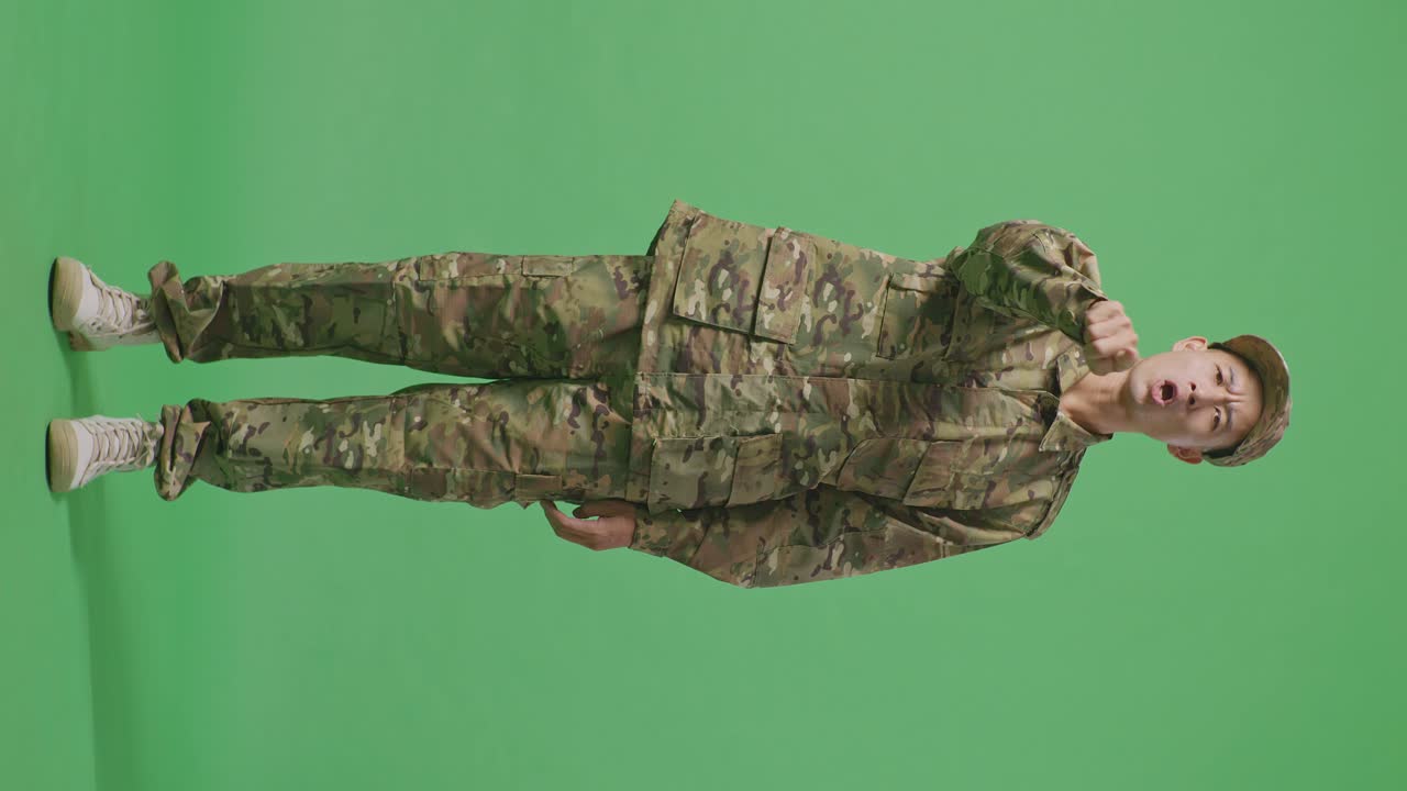 Full Body Of Asian Man Soldier Shouting To Camera While Standing In The Green Screen Background Studio
