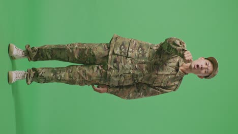 full body of asian man soldier shouting to camera while standing in the green screen background studio