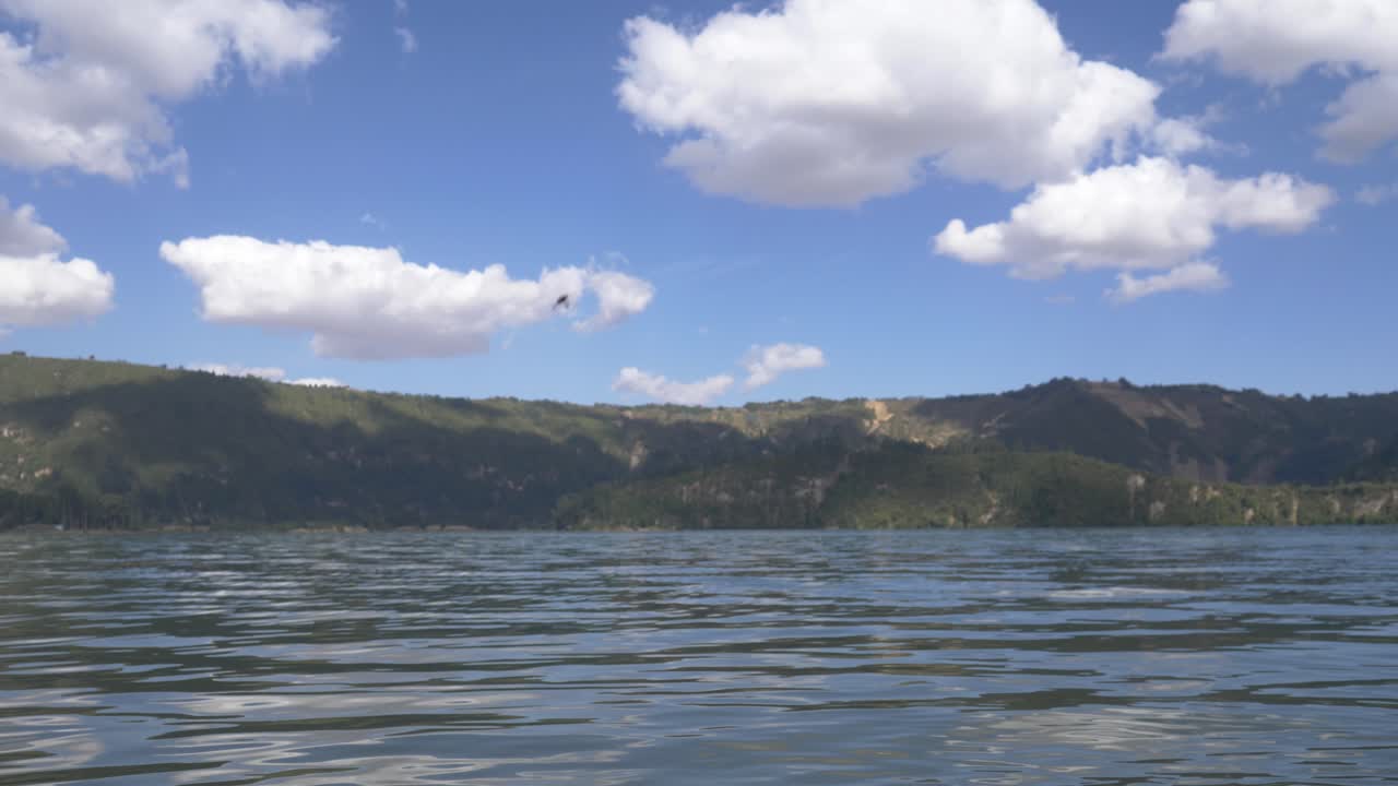 tirar una piedra al lago para tener suerte y divertirse mientras el cielo y las nubes beige hacen que el día sea muy divertido.