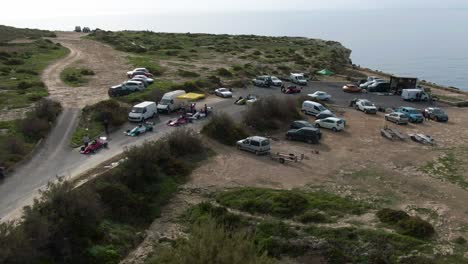 racing cars waiting for the race start at the starting point of the road track near cars parked on the hill - aerial shot