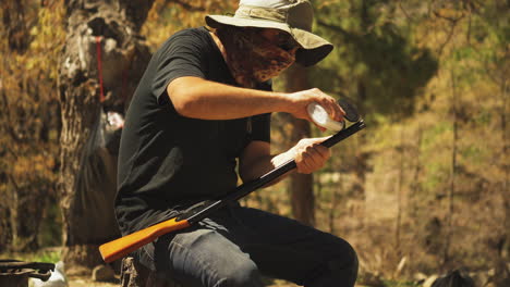 Close-up-of-man-reloading-his-air-powered-bb-gun-with-ammo-while-shooting-for-target-practice