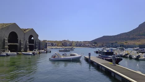 famous florio tuna factory or tonnara at port of favignana and santa caterina castle on top of mountain, italy