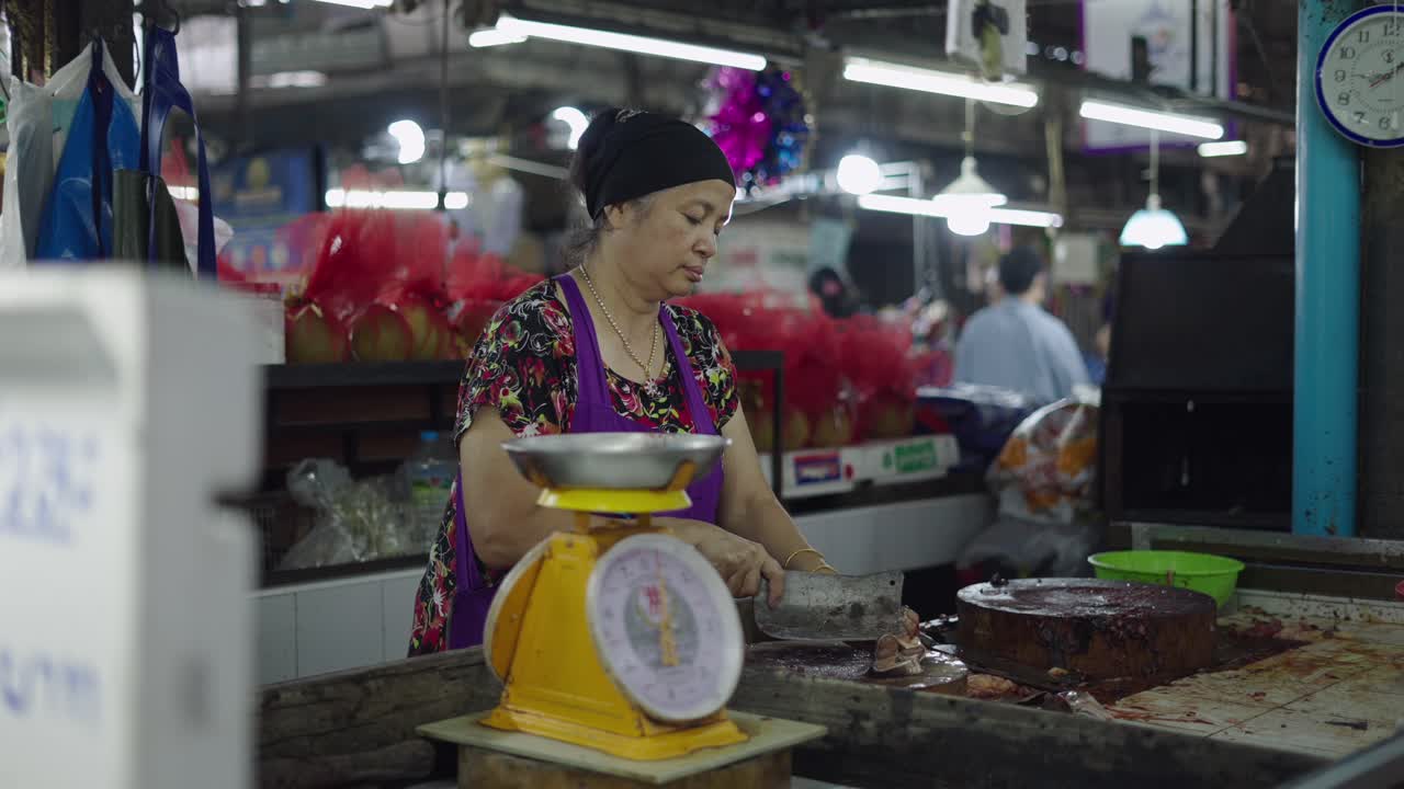 Woman Weighing and Cutting Fresh Fish in a Market